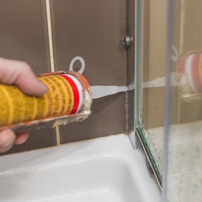 Replacing silicone on shower using a caulking gun